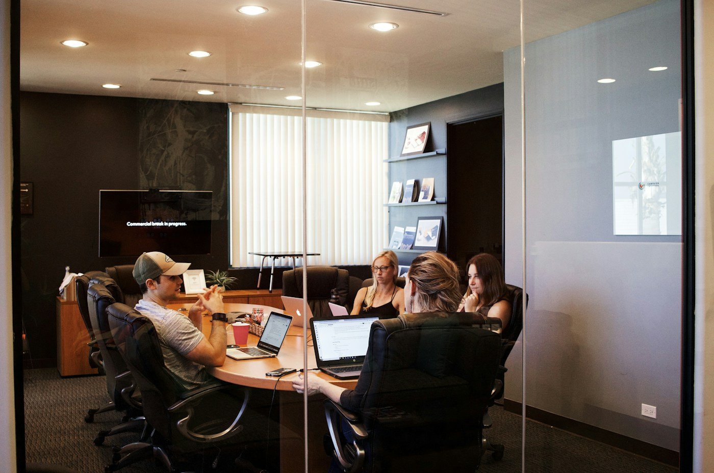 Professionals collaborating around laptops in a bright office
